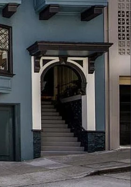 The arched entry and steep steps of the Clay Street Victorian in San Francisco